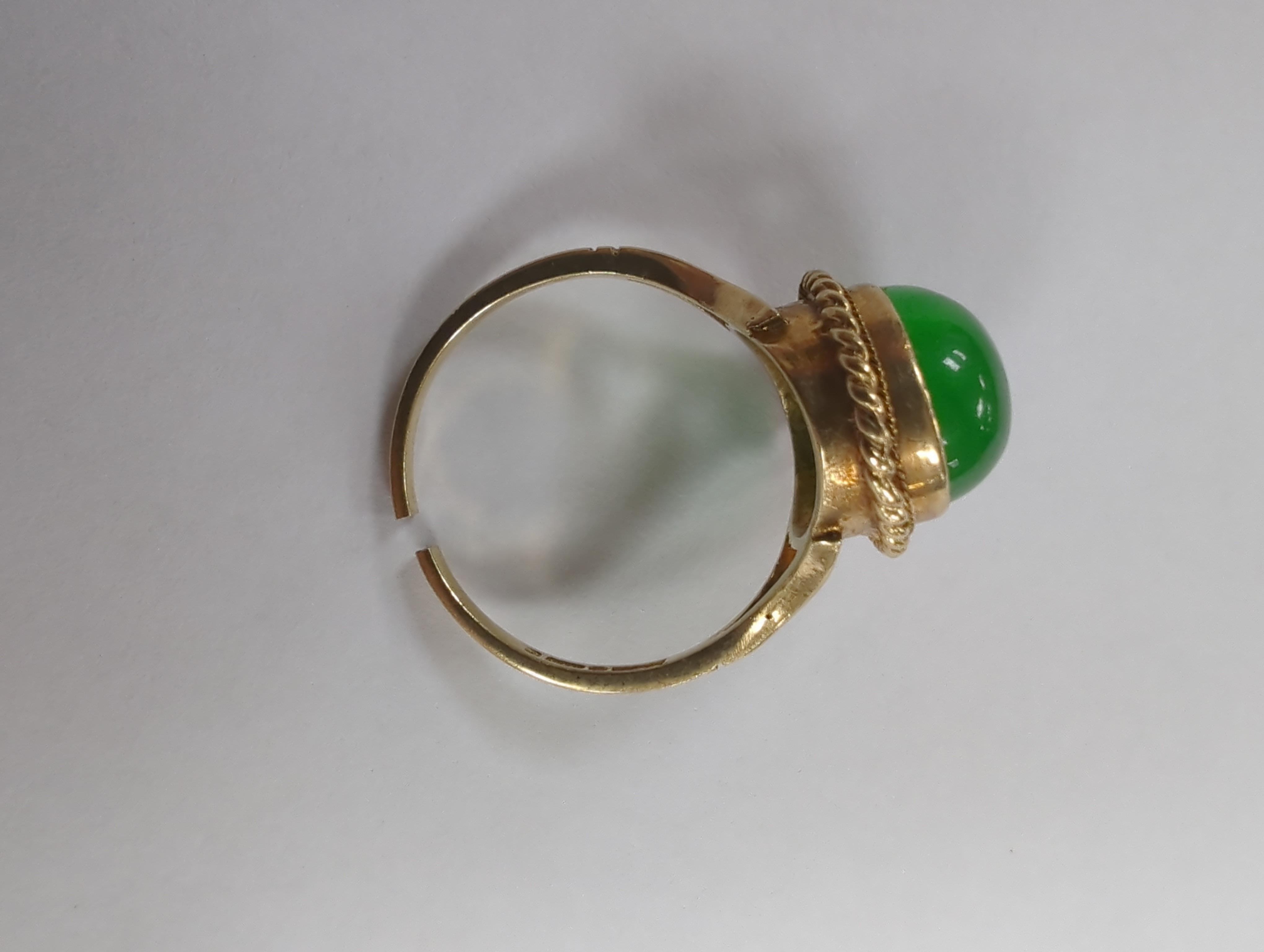 A 9ct gold and cabochon jade set oval ring (shank cut), gross weight 4.3 grams.